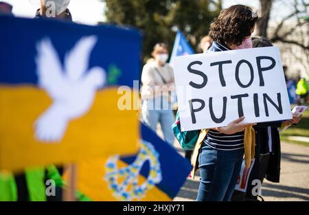 Stuttgart, Deutschland. 13. März 2022. Während einer Demonstration im oberen Schlossgarten gegen den russischen Militäreinsatz in der Ukraine hält eine Frau ein Schild mit der Aufschrift „'Stop Putin'“ in der Hand. Quelle: Christoph Schmidt/dpa/Alamy Live News Stockfoto