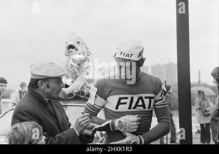 Eddy Merckx wird gebeten, sein Autogramm für einen Fan zu unterschreiben, da er am Samstag, den 11.. Juni, am größten Rennrad-Event des britischen Berufsstandes, dem Glenryck Cup 1977 auf dem Eastway Cycling Track, Lee Valley bei Stratford, London, teilnimmt. Sieger wurde der Westdeutsche Dietrich Thurau. 2. war die britische Sid Barras und Dritter war der Belgier Eddy Merckx. Eddy Merckx richtiger Name ist Édouard Louis Joseph, Baron Merckx Bild aufgenommen am 11.. Juni 1977 Stockfoto