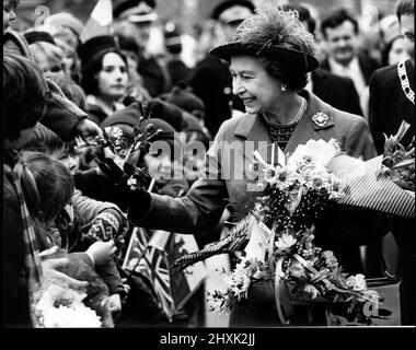 Königin Elizabeth II. Trifft die fröhliche Menge auf ihrem Rundgang, nachdem sie das Delyn Borough Council Offices in Flint, Nordwales, eröffnet hat.die Königin ist auf ihrer Silberjubiläum-Tour im Juni 1977 durch Wales. 22.. Juni 1977. Stockfoto