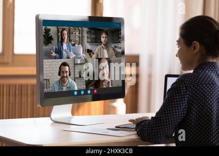 Indische Frauen sprechen mit verschiedenen jungen Menschen in Gruppen-Videocall Stockfoto