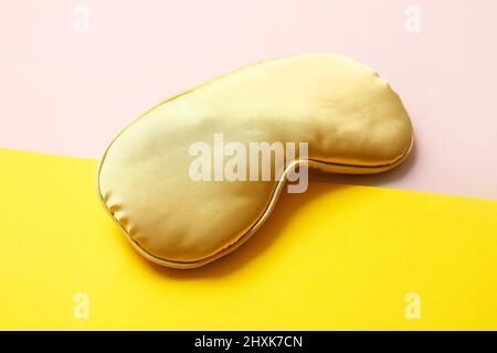 Gelbe Schlafmaske auf farbigem Hintergrund Stockfoto