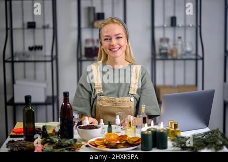 Portrait des Parfumeurs Nehmen Sie eine Flasche zum Mischen von Duft und ätherischem Öl in eine andere Flasche während des Mischen des schönen Duftes zur Herstellung von Perf Stockfoto