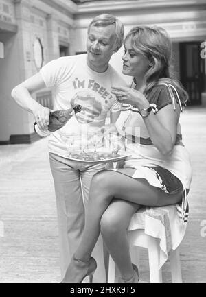 John Inman (Mr Humphries) und Wendy Richard (Miss Brahms) aus der Besetzung der BBC-TV-Situationskomödie sind Sie hier zu sehen, um den Erfolg ihrer Sommershow zu feiern. August 1976 Stockfoto