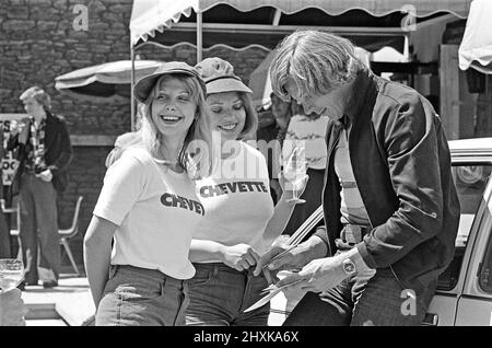 Motorrennfahrer James Hunt signiert sein Autogramm für zwei seiner weiblichen Stewardessen bei einem Chevette Meet and Greet Event. Stadt und Ort unbekannt Aufnahme aufgenommen um den 1.. August 1976 Stockfoto