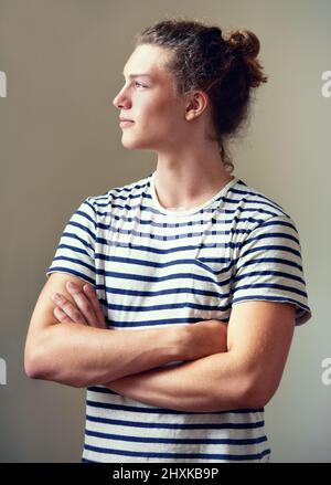 Fühlen Sie sich gelassen. Profilaufnahme eines jungen Mannes, dessen Haare in einem Brötchen wegschauen. Stockfoto