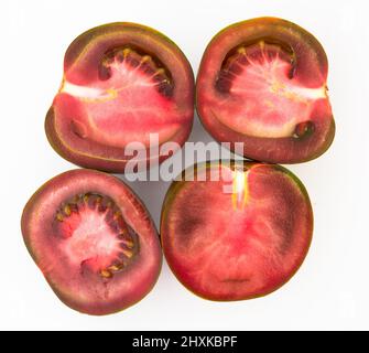 Schwarze Hälften von Tomaten auf weißem Hintergrund Stockfoto