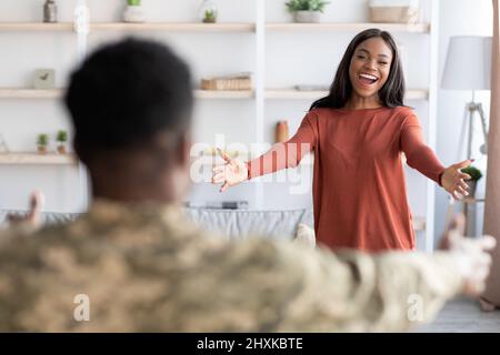 Glückliche Frau, Die Ihren Mann Im Militärdienst Willkommen Hieß, Nachdem Sie Von Der Armee Nach Hause Zurückgekehrt War Stockfoto