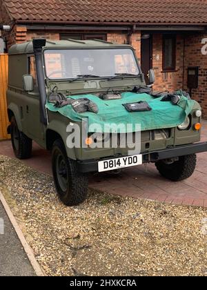 Militärischer Land Rover in grünen Armeefarben mit Leinwand auf der Vorderseite aus Kunststoff Land Rover Wolfsverteidiger Ex-Militär British Army Stockfoto