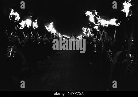 Das Lerwick Up Helly AA Festival ist eine Tradition, die im Jahr 1880s ihren Ursprung hat. Seitdem ist das Fest ein jährliches Ereignis im Shetland-Kalender. Unser Bild Zeigt. Die Up Helly AA Prozession. Nach Einbruch der Dunkelheit wird die nachgebaute Wikinger lange Schiffskolley in einer Fackelprozession durch die Straßen der Stadt geschleppt. Die Fackelträger sind die Mitglieder aller Guizer-Kader, angeführt von der Jarl-Kader. Jeder Trupp wählt ein Thema aus und kleidet sich entsprechend. Die Themen sind sehr vielfältig, teils historisch, teils aktuell oder satirisch. 27.. Januar 1976 Stockfoto