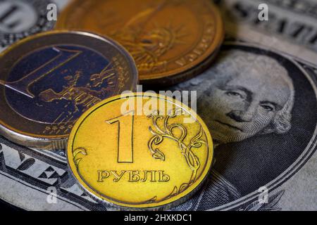 Russische Rubel Euro- und US-Dollar-Münzen auf Dollar-Banknote. Ukraine Krieg Sanktionen Wechselkurskonzept. Stockfoto