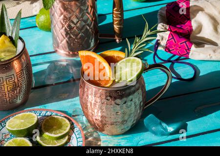 Sommerliche Cocktails, garniert mit frischem Obst und Kräutern, bei hellem Sonnenlicht. Stockfoto