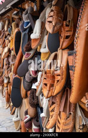 Sammlung von vielen traditionellen handgefertigten bunten Schuhen auf dem Basar oder Markt in Skopje. Hintergrund mit Schuhstruktur-Muster Stockfoto