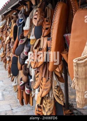 Sammlung von vielen traditionellen handgefertigten bunten Schuhen auf dem Basar oder Markt in Skopje. Hintergrund mit Schuhstruktur-Muster Stockfoto