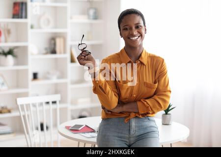 Glückliche junge schwarze Frau posiert zu Hause Stockfoto