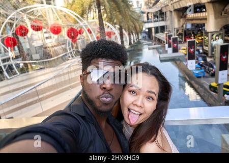 Zwei Freunde, die sich an der Kamera eines Mobiltelefons festmachen, während sie ein Selfie-Foto machen Stockfoto