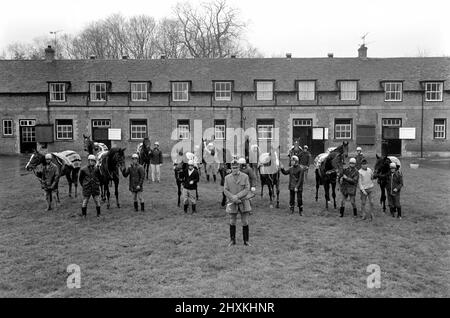 Jockey Willie Carson. „All the Queens Horses“. In West Ilsley steht Berks-Trainer Major W. R. Hern vor den 13 Pferden für die Queen. Von links nach rechts: Hintere Reihe Star Harbour; Circlet; Alma; Tartan Pimpernell; Dunfermline; Und Mary Fitton. Erste Reihe: Bewertung; Kette der Argumentation; Fife und Trommel; Herzog der Normandie; Rhyme Royal; Gesellig und Paintbrust. Der Mann 2. von rechts ist Stan Clayton, ehemaliger Jockey der Queen. 1977 77.-02213-014. April Stockfoto