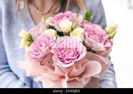 Nahaufnahme eines Straußes Rosen in weiblichen Händen. Stockfoto