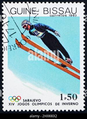 GUINEA-BISSAU - UM 1983: Eine in Guinea-Bissau gedruckte Marke zeigt Skispringen, Olympische Winterspiele 1984, Sarajevo, um 1983 Stockfoto