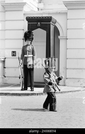 Mark Acklom, 3 Jahre, aus Greenways, Beckenham, Kent, in einem Miniaturgarden-Outfit, komplett mit Gewehr, steht vor dem Clarence House, London, 10.. Juni 1976, als Wache. Stockfoto