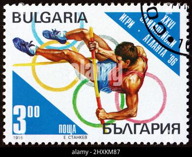 BULGARIEN - UM 1995: Eine in Bulgarien gedruckte Briefmarke zeigt den Stabhochsprung, die Olympischen Sommerspiele 1996, Atlanta, um 1995 Stockfoto