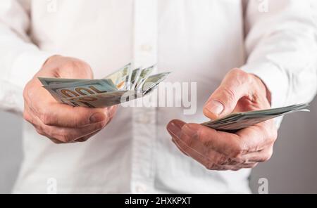 Hände aus der Nähe zählen US-Dollar-Scheine, Papierwährung. Konzept der Gehaltszahlung. Stockfoto