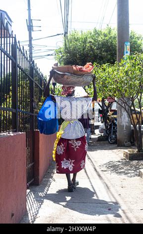 Porträt einer älteren Verkäuferin, palenquera, die wegging und eine große Schüssel auf dem Kopf hielt, Cartagena de Indias, Kolumbien. Stockfoto