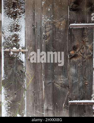 Details der alten, von Schnee bedeckten Holzscheune Stockfoto