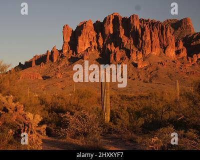 Sonnenuntergangsbilder am Superstition Mountain in Arizona und Umgebung. Die untergehende Sonne taucht die Gegend in goldene Rottöne. Stockfoto