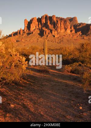 Sonnenuntergangsbilder am Superstition Mountain in Arizona und Umgebung. Die untergehende Sonne taucht die Gegend in goldene Rottöne. Stockfoto