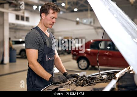 Car-Service, Reparatur, Wartung. kaukasische Techniker überprüft sammeln detaillierte Informationen während der Arbeit. Service-Wartung von industriellen zu Motor re Stockfoto