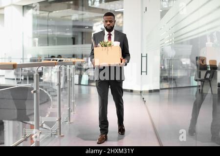 Unglücklicher afroamerikanischer junger Mann, der mit Arbeitsmaterial beschäftigt war Stockfoto