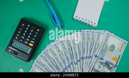 Viele Dollar Geld schaffen Muster, machen Design Form Bild. Draufsicht, flach liegend. Erstellen Sie runden Kreis, machen Design Form Bild. Geldnotendollar, Taschenrechner, Stift, Notizblock auf dem Hintergrund. Stockfoto