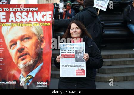 Eine kleine Gruppe von Demonstranten, die Plakate halten, setzt sich dafür ein, Julian Assange aus dem Gefängnis im Piccadilly Circus, London, Großbritannien, zu befreien Stockfoto