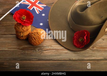 Australischer Anzac-Tag. Hut der australischen Armee und traditionelle Anzac-Kekse auf Holzhintergrund. Stockfoto