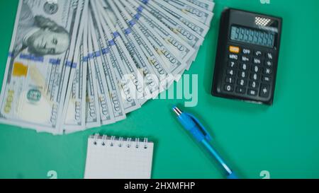 Viele Dollar Geld schaffen Muster, machen Design Form Bild. Draufsicht, flach liegend. Erstellen Sie runden Kreis, machen Design Form Bild. Geldnotendollar, Taschenrechner, Stift, Notizblock auf dem Hintergrund. Stockfoto