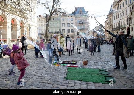 Lviv, Ukraine. 13. März 2022. Kinder werden im Stadtzentrum von Lviv beim Spielen mit Seifenblasen gesehen. Zivilisten in Lemberg versuchen, ihren Alltag zu leben, trotz des heutigen morgendlichen russischen Bombenanschlags auf einen Militärstützpunkt außerhalb von Lemberg. (Bild: © Hesther Ng/SOPA Images via ZUMA Press Wire) Stockfoto