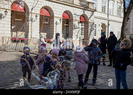 Lviv, Ukraine. 13. März 2022. Kinder werden im Stadtzentrum von Lviv beim Spielen mit Seifenblasen gesehen. Zivilisten in Lemberg versuchen, ihren Alltag zu leben, trotz des heutigen morgendlichen russischen Bombenanschlags auf einen Militärstützpunkt außerhalb von Lemberg. (Bild: © Hesther Ng/SOPA Images via ZUMA Press Wire) Stockfoto