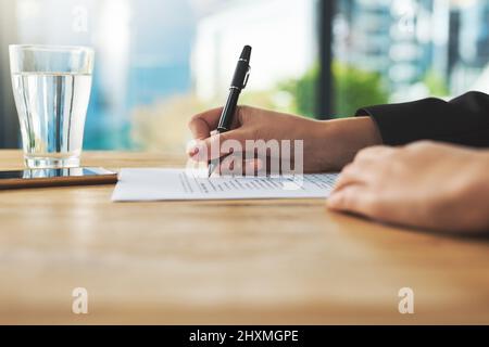 Durchsuchen einiger Dokumente. Aufnahme einer Frau, die einen Papierkram ausfüllt. Stockfoto