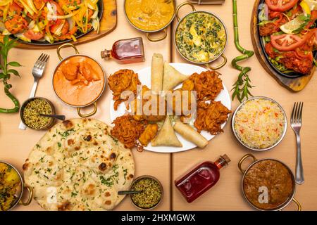 Indische Gerichte, mit gebratenem Huhn Tikka Masala, Knoblauch Naan, Joghurt-Creme, Korma, Tandoori-Huhn, Tomatensalat, Palak Paneer, Pfeffer, Basmati r Stockfoto