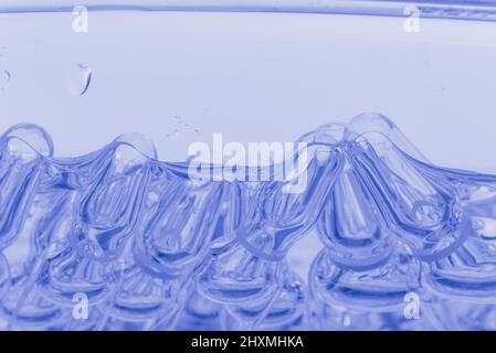 Medizinische Ampullen aus Glas zur Injektion. Medizin ist flüssiges Natriumchlorid mit wässriger Lösung in Ampulla. Nahaufnahme. Flaschen Ampulle Multicolor auf Hintergrundfarbe und Wasser. Humanplasma. Stockfoto