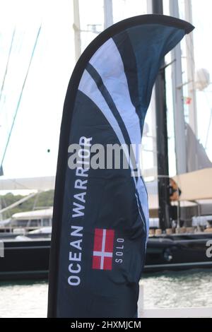 Flagge mit der Aufschrift "Ocean Warrior" mit dänischer Flagge und Yachten im Hintergrund Stockfoto