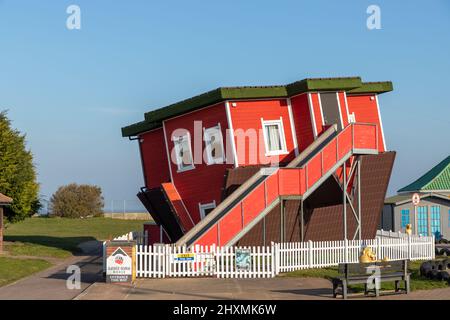 Die Upside Down House Attraktion am Great Yarmouth Pleasure Beach in North Norfolk in Großbritannien an einem wunderschönen Nachmittag mit blauem Himmel im März Stockfoto