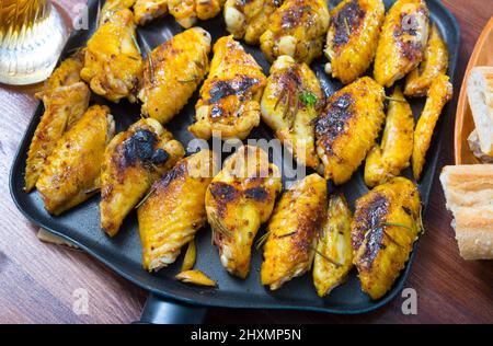 Hähnchenflügel auf Frypan mit Sauce Stockfoto