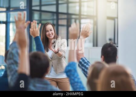 Das Publikum hat die Antwort. Aufnahme einer Gruppe von Menschen, die in einem Seminar die Hände heben. Stockfoto