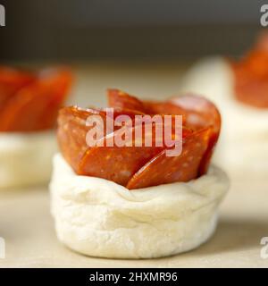 Roséförmige Pfefferoni-Torte. Gebäck mit Salami. Hausgemachtes Blätterteig bereit zum Backen. Stockfoto