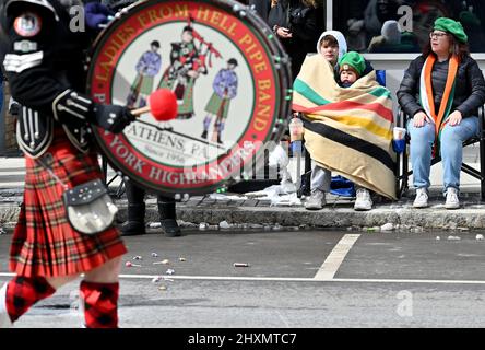 Wilkes Barre, Usa. 13. März 2022. Die Menschen sahen in Decken gehüllt, wie sie die St. Patrick's Parade beobachten, bei der die Temperaturen nicht über 30 Grad anstiegen. Der Wintersturm am Samstag hinterließ 5 cm Schnee, aber die Saint Patrick's Parade in der Innenstadt von Wilkes-Barre verlief am Sonntag. Stadtarbeiter haben am späten Samstag und frühen Sonntag die Straßen geräumt. Die Temperatur für die Parade kam nie über 30 Grad. Kredit: SOPA Images Limited/Alamy Live Nachrichten Stockfoto