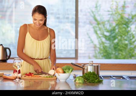 Soupy Güte. Eine junge Frau schneidet Gemüse in der Küche. Stockfoto