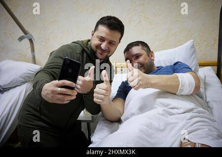 (Kiew, Ukraine - 13,3.22) der ukrainische Präsident Wolodymyr Zelenski geht zu einem Militärkrankenhaus in Kiew, Ukraine, um dort Soldaten zu besuchen, die während der russischen Invasion verwundet wurden, und verleiht den Kämpfern und dem medizinischen Personal Medaillen für ihren Dienst an ihrem Land. (Foto: Presidential Press Office Der Ukraine) Stockfoto