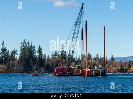 Kleines Schleppboot, das Barge und Pfahlfahrer auf Vancouver Island schleppt. Stockfoto