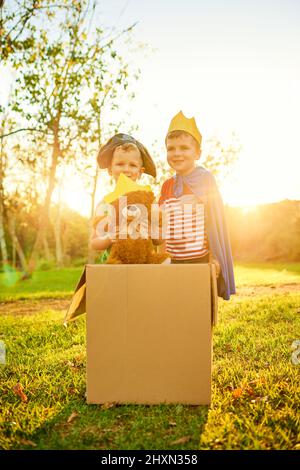 Der Pirat und der Prinz. Portrait von zwei kleinen Jungen, die in Kostümen verkleidet sind und im Freien zusammen spielen. Stockfoto